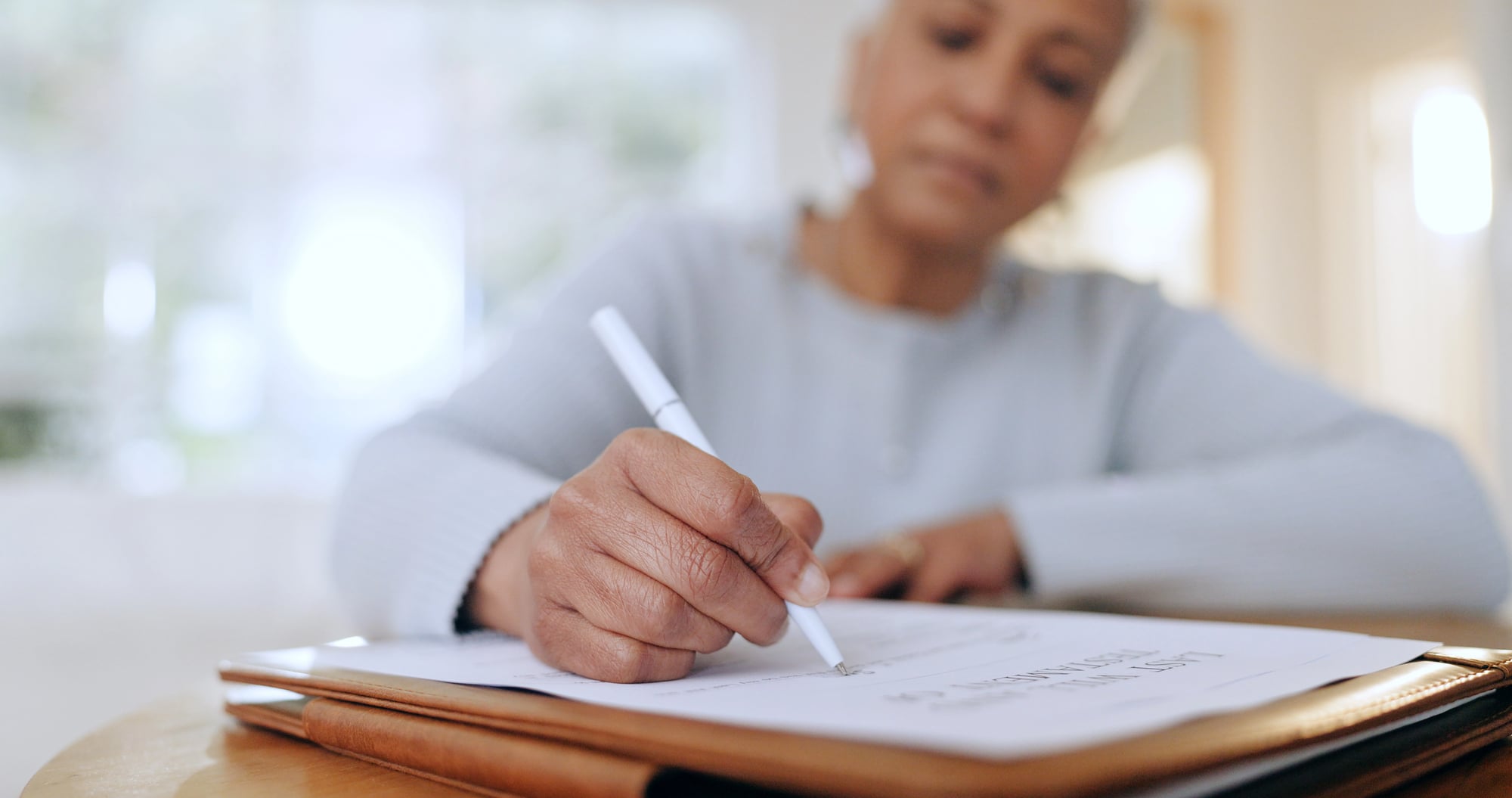 Senior woman completing life insurance policy application paperwork